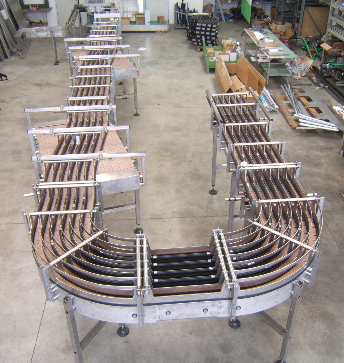 Strutture curve in acciaio inox con guide per nastri in officina
